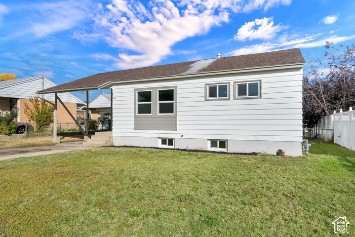 Single-story exterior featuring horizontal siding, a covered carport, and multiple windows