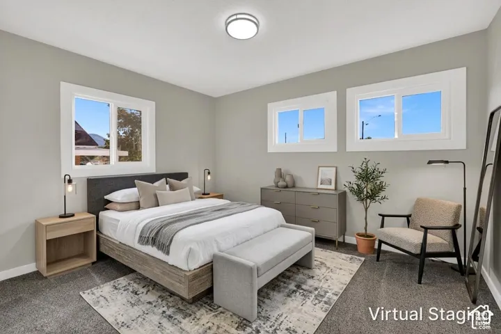 Neutral-toned room featuring neutral carpeting, three horizontal slider windows with white trim, and a centered flush-mount ceiling light fixture
