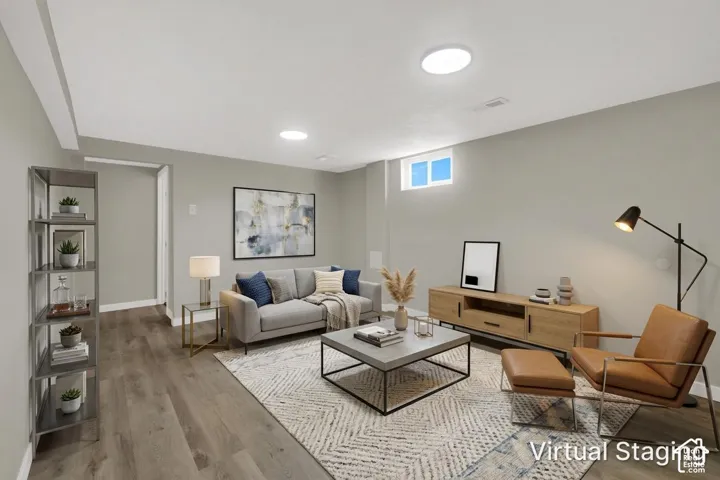Neutral-toned interior space featuring wood-finish flooring, recessed lighting, and a single hopper-style window