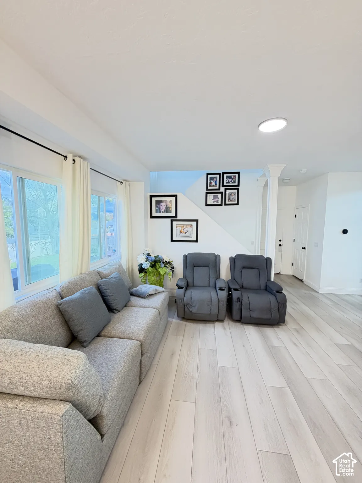 Light-filled interior space featuring neutral walls, wood-finish flooring, large picture windows, and recessed ceiling lighting