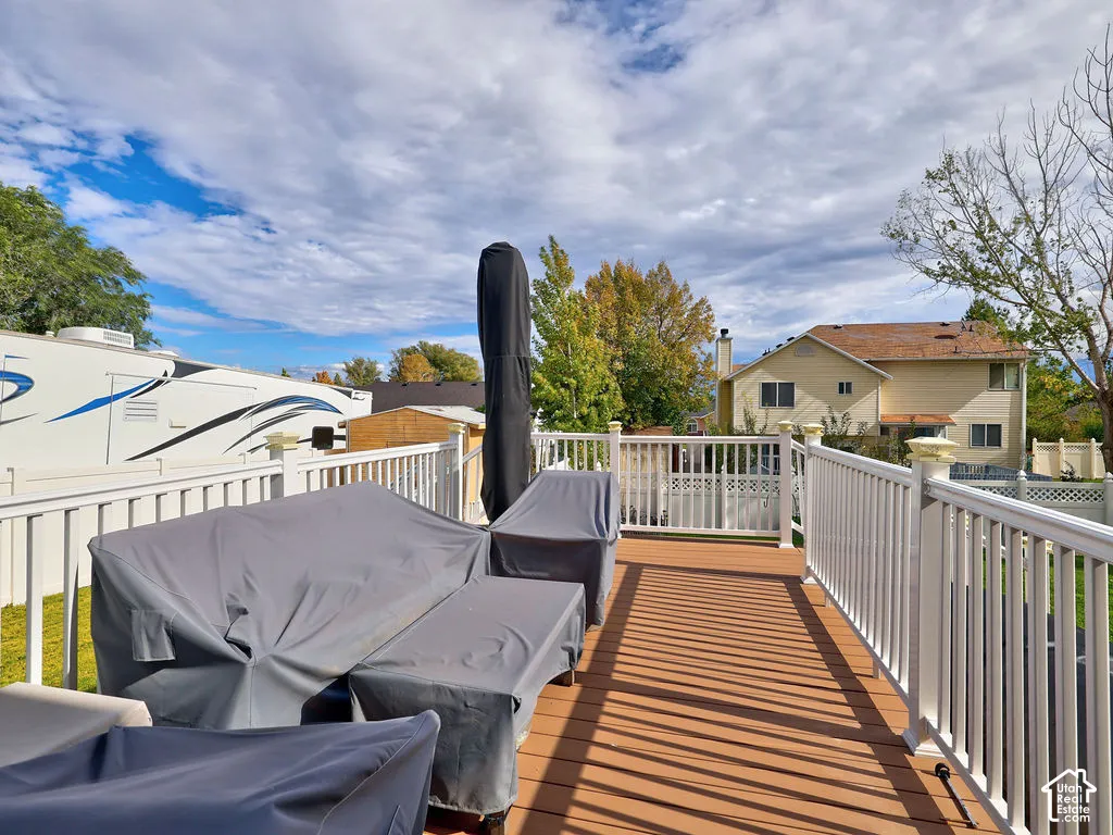 Elevated deck featuring wood-finish composite decking and white vinyl railing