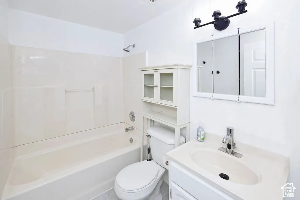 Bathroom featuring a molded composite tub and shower surround, a white vanity cabinet with an integrated sink, a multi-panel mirrored medicine cabinet, and three-light matte black vanity fixture