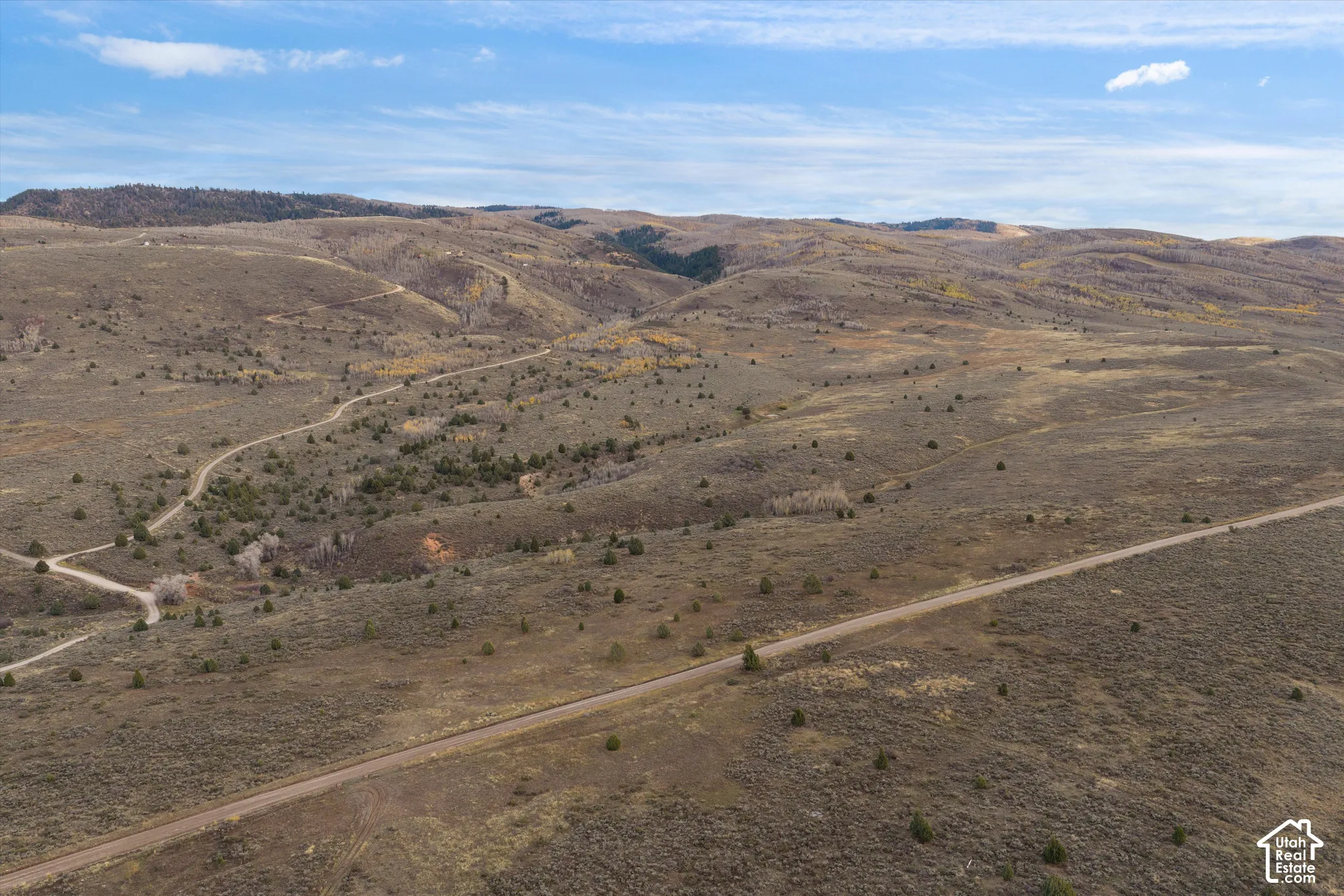 Expansive acreage featuring rugged mountain terrain, established dirt access roads, native vegetation, and panoramic topography