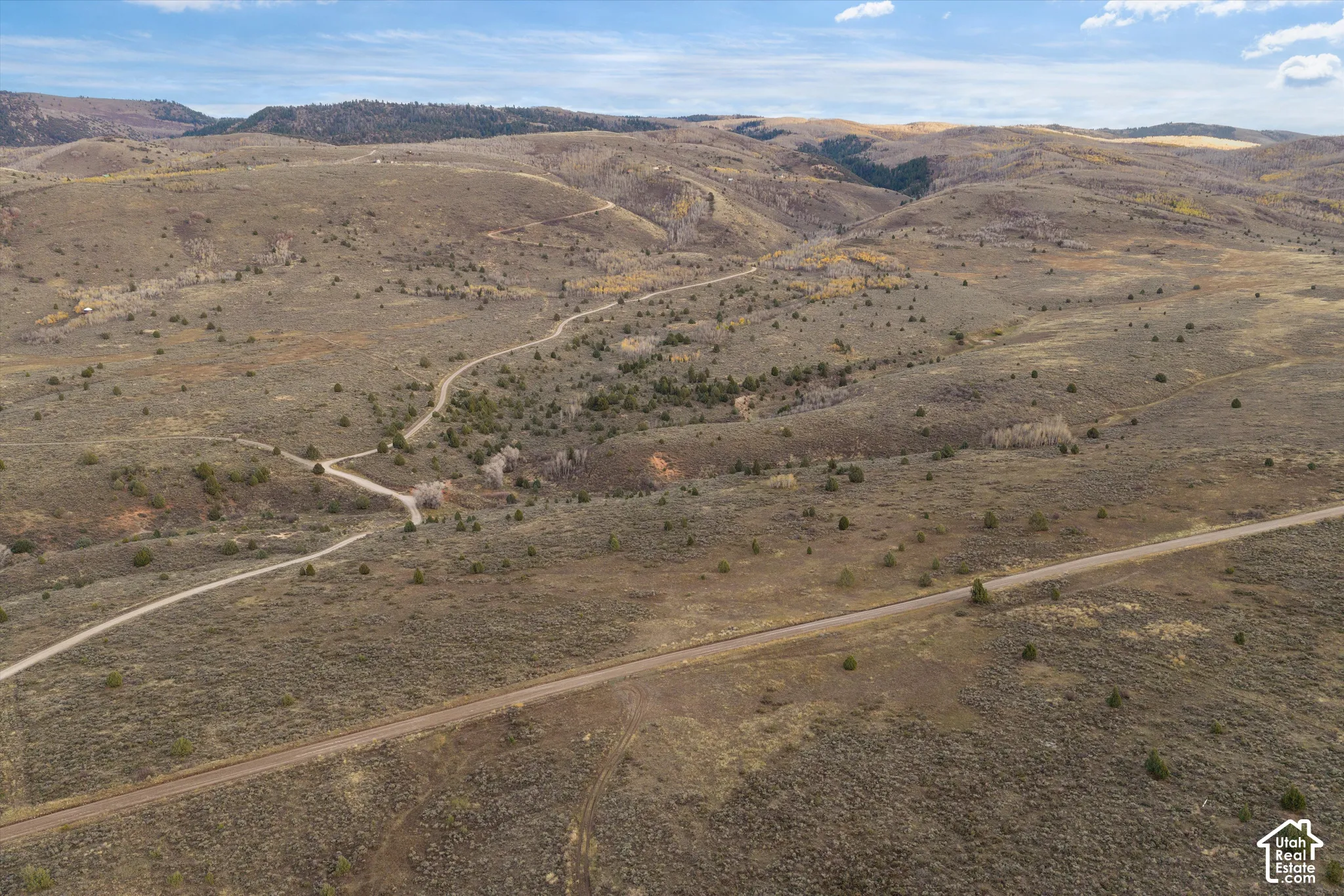 Expansive acreage featuring rugged mountain topography, native shrubland, rolling hills, and unpaved access paths