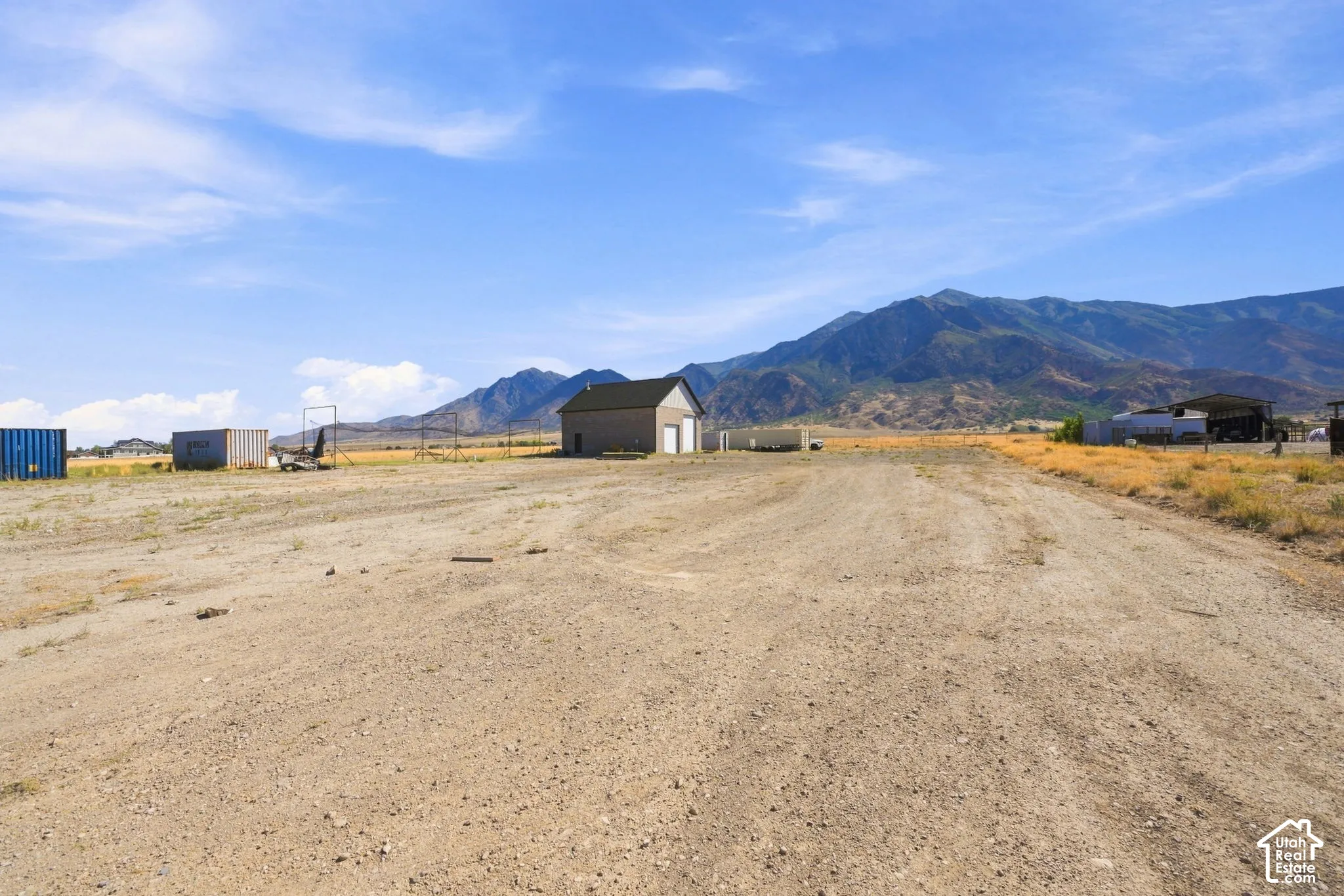 Expansive lot featuring an exterior structure, natural terrain, and mountain scenery