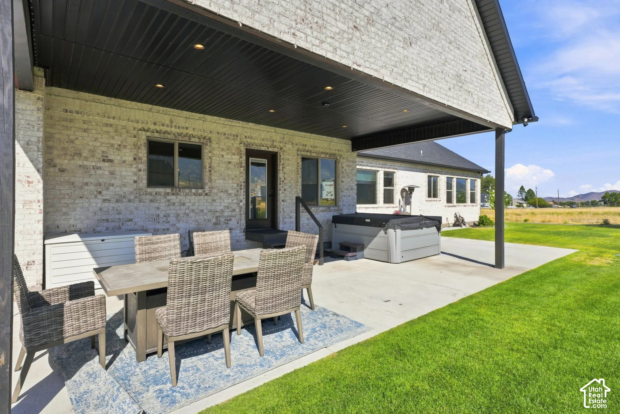 Covered brick patio featuring a dark-finished ceiling with recessed lighting and a concrete slab foundation