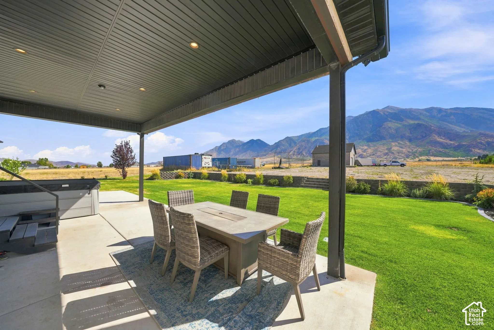 Covered concrete patio featuring recessed lighting, a built-in spa, and mountain backdrops