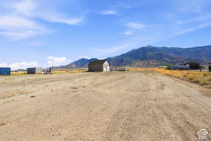 Expansive lot featuring an exterior structure, natural terrain, and mountain scenery
