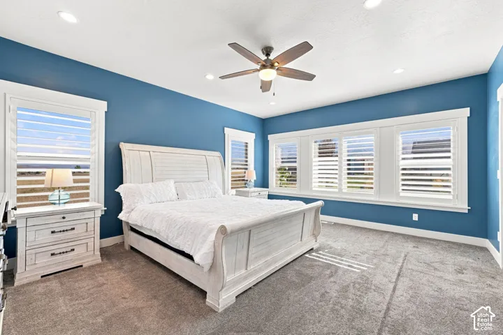 Room featuring recessed lighting, multi-panel windows with plantation shutters, neutral-tone carpeting, and a ceiling fan with integrated light fixture