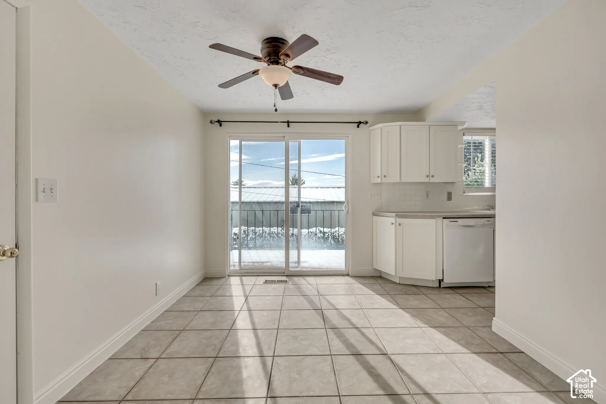 Dining area featuring tile flooring, a ceiling fan, and a sliding glass door
