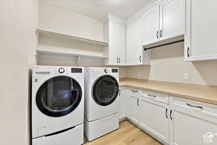 Laundry area featuring white shaker-style cabinetry, solid-surface countertops, wood-finish flooring, built-in shelving, and a garment hanging rod