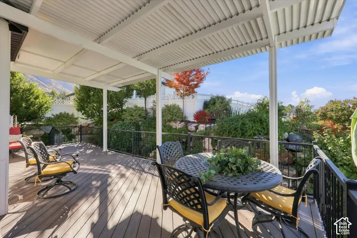 Covered deck with composite decking, black metal railing, and mountain backdrop