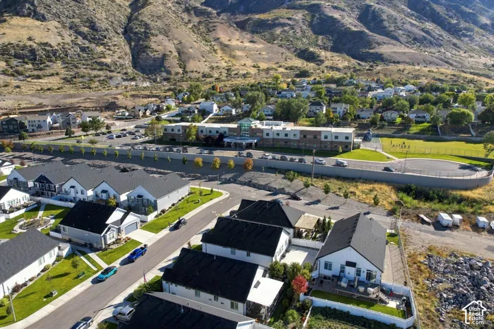 Aerial perspective featuring mountain topography, asphalt roadways, residential housing, and clear lot boundaries