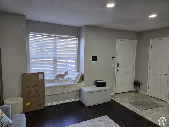 Entryway featuring wood-finish flooring, tile entry, recessed lighting, built-in window seat, and electronic security wall panel