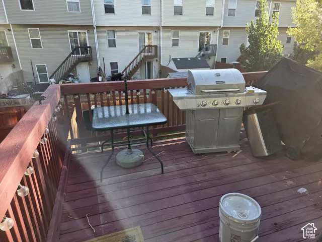 Elevated wooden deck featuring a stained finish and perimeter railing with string lighting