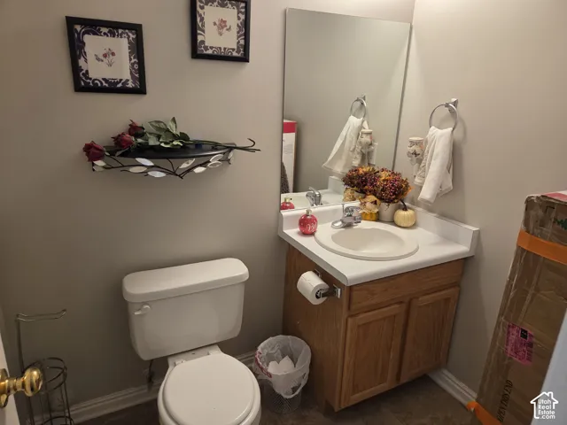 Vanity featuring a white countertop with integrated basin, wooden cabinetry, wall-mounted mirror, and chrome hardware