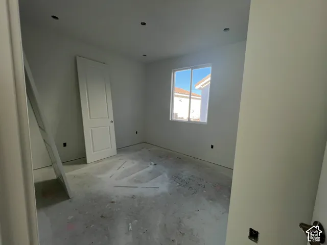Interior room featuring a single-panel interior door, recessed lighting, and a dual-pane sliding window