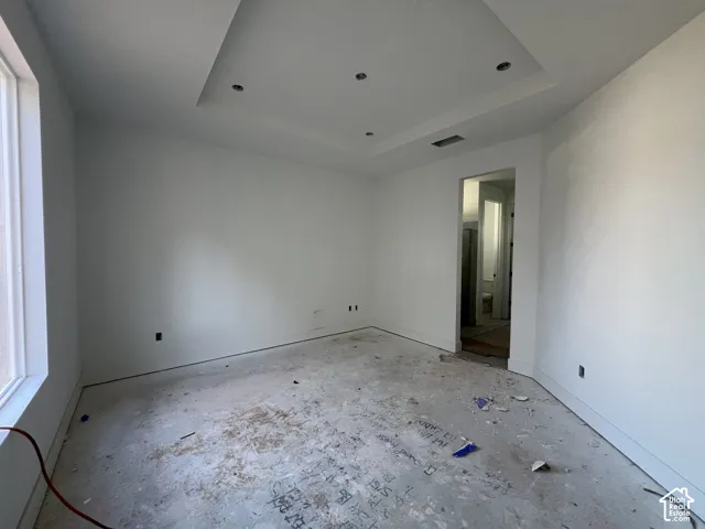 Tray ceiling featuring recessed lighting and a large window