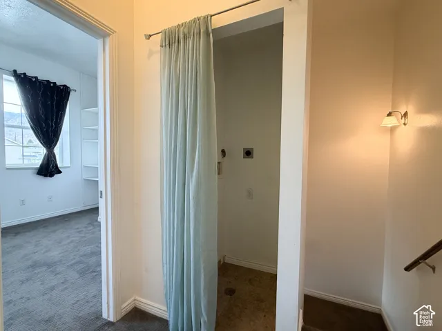 Laundry area featuring utility hookups, drain, and wall-mounted light fixture