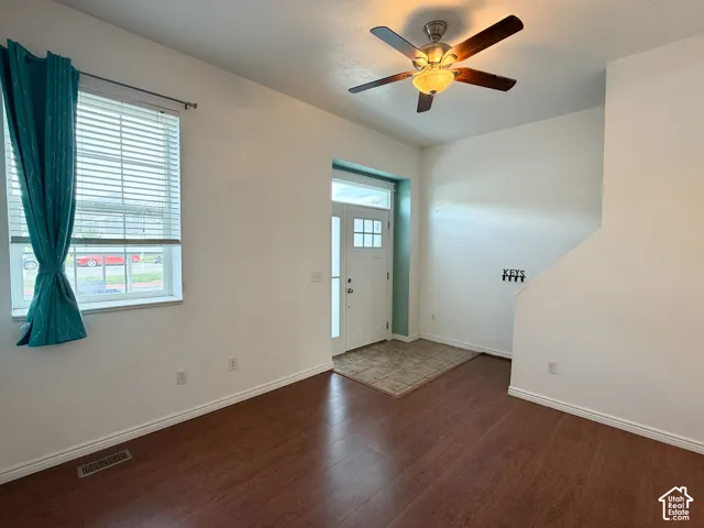 Entryway featuring wood-finish flooring, ceramic tile flooring, a multi-pane glass entry door, and a ceiling fan with integrated lighting