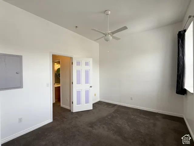 Room featuring high ceilings, wall-to-wall carpeting, and a white ceiling fan with integrated lighting