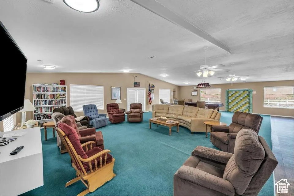 Expansive interior space featuring vaulted ceilings, recessed lighting, built-in floor-to-ceiling shelving, and multiple ceiling fans