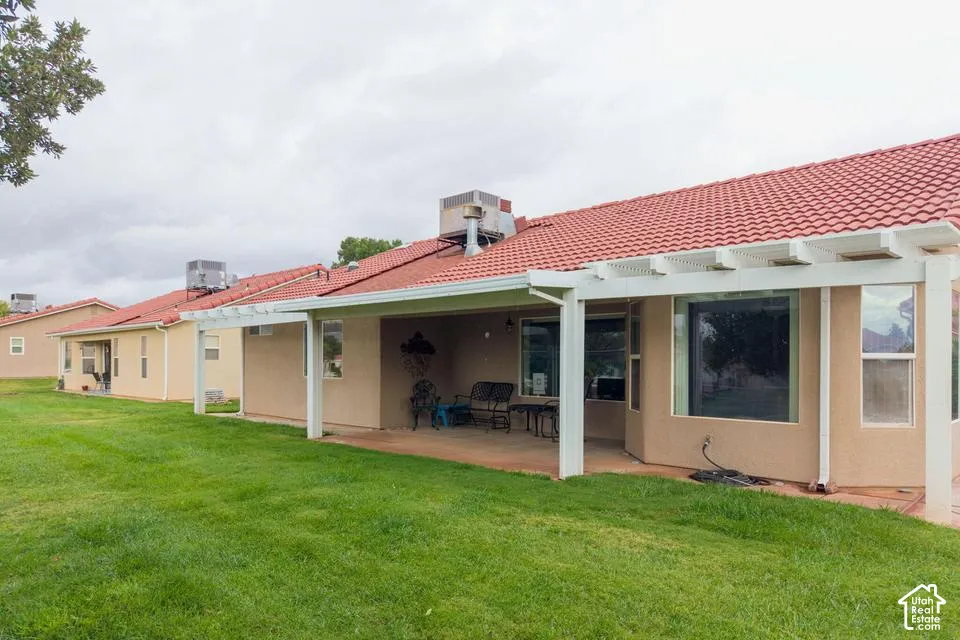 Exterior featuring a stucco facade, red tile roof, and a covered patio with a white pergola structure