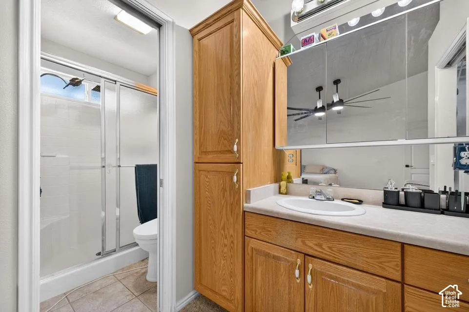 Bathroom vanity with wood-finish cabinetry, countertop, and integrated oval basin