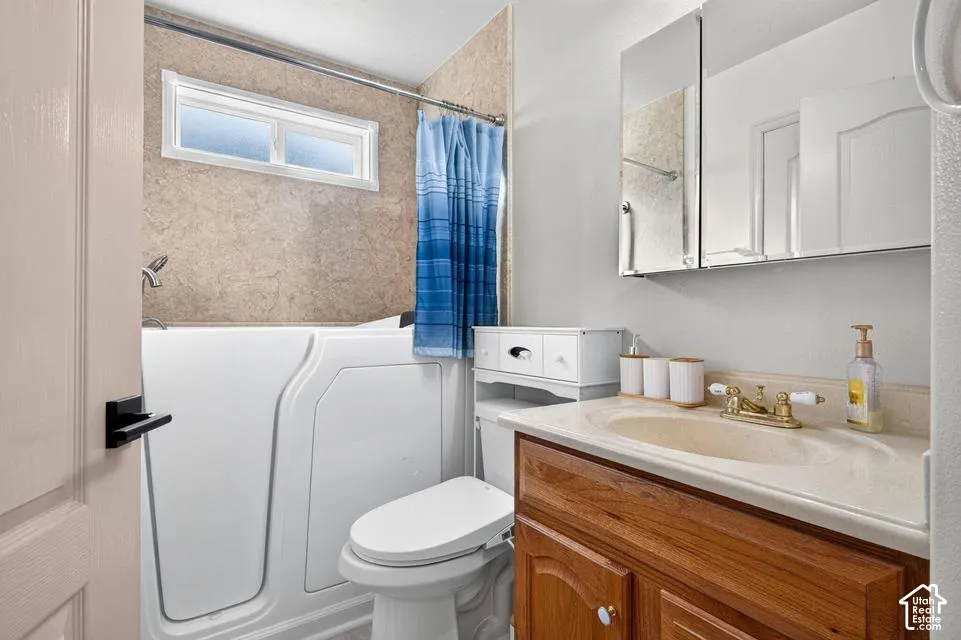 Walk-in tub with integrated surround, wood-finish vanity cabinet, solid-surface countertop with drop-in sink, and medicine cabinet with mirrored doors