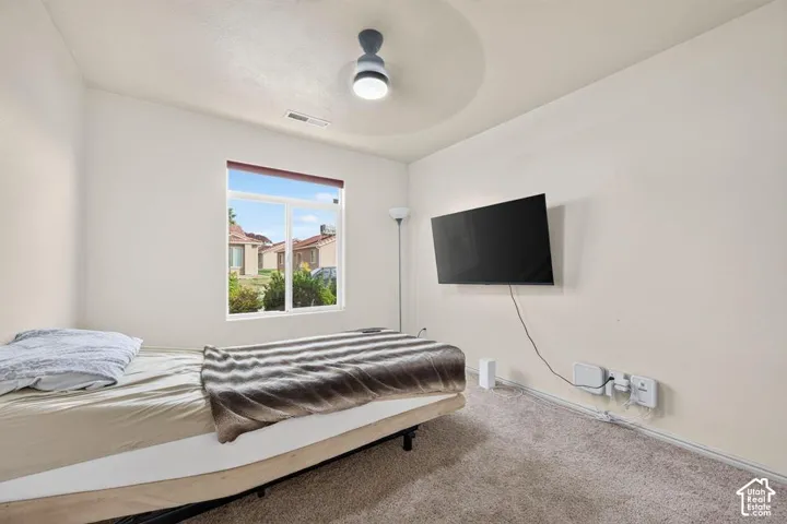 Neutral wall-to-wall carpeting, window with natural light, and modern ceiling-mounted light fixture