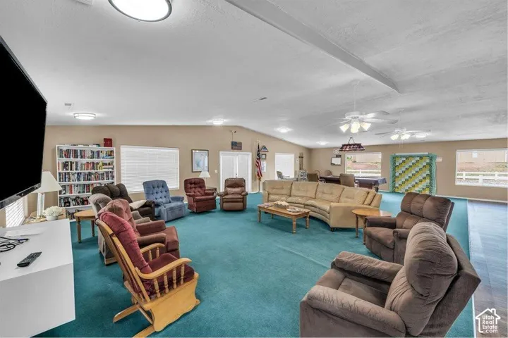Expansive interior space featuring vaulted ceilings, recessed lighting, built-in floor-to-ceiling shelving, and multiple ceiling fans