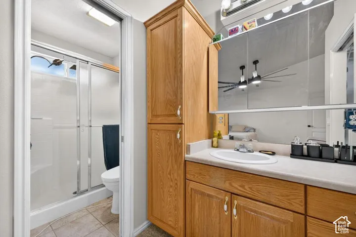 Bathroom vanity with wood-finish cabinetry, countertop, and integrated oval basin