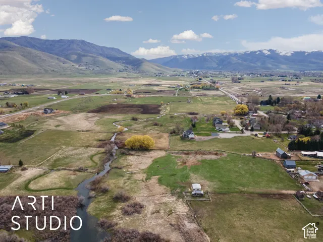 Expansive acreage featuring a winding creek, mature trees, and mountain scenery