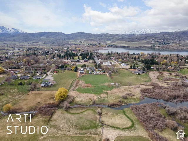 Aerial expanse featuring open terrain, natural waterways, and a mountain backdrop