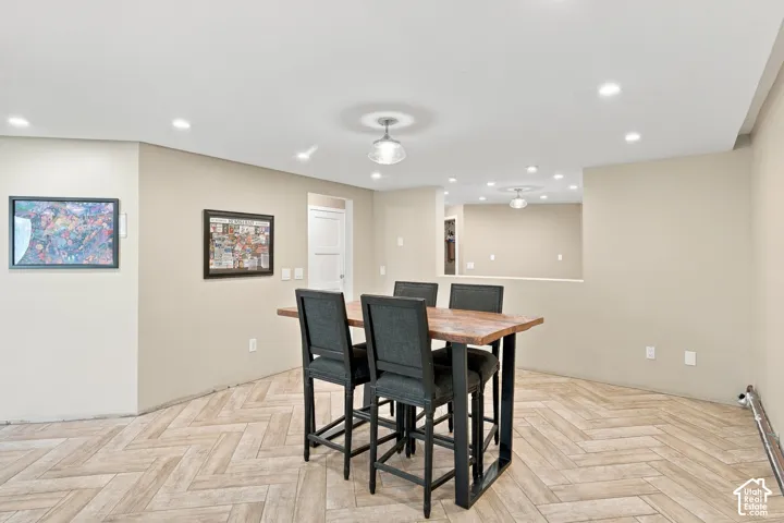Interior space featuring herringbone-patterned tile flooring, recessed ceiling lighting, and a neutral color palette