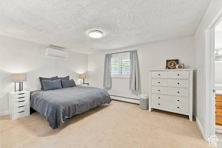 Wall-mounted climate control unit, textured ceiling, flush-mount light fixture, and window with plantation-style shutters