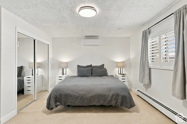 Wall-mounted ductless air conditioning unit, sliding mirrored closet doors, adjustable plantation shutters, and flush-mount ceiling lighting