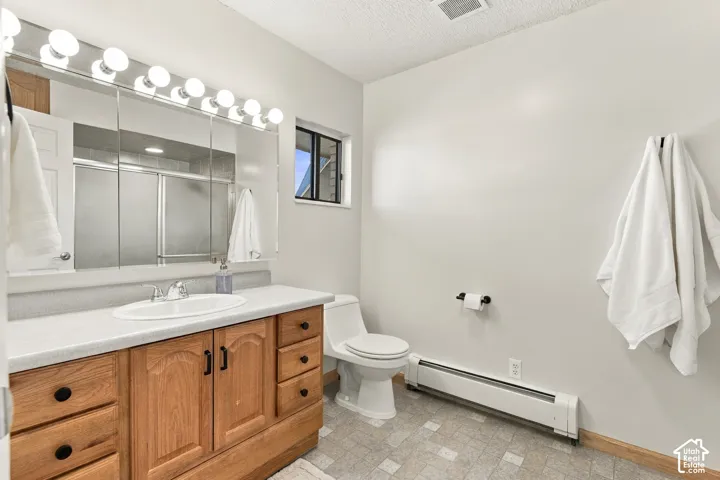 Bathroom vanity featuring stained wood cabinetry, a solid surface countertop, an integrated oval basin, and a multi-bulb vanity light fixture