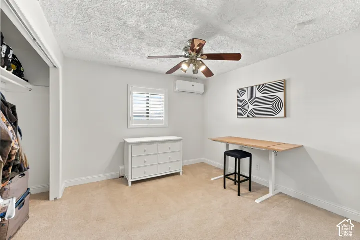 Wall-mounted climate control unit, ceiling fan with integrated lighting, window with shutter treatments, and reach-in closet with built-in shelving