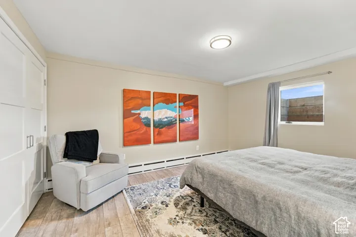 Room featuring wood-finish flooring, recessed lighting, and a multi-panel closet with shaker-style doors