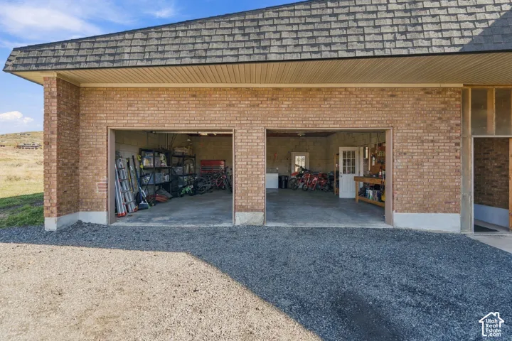 Two-car detached garage featuring brick masonry exterior, asphalt shingle roofing, and concrete flooring