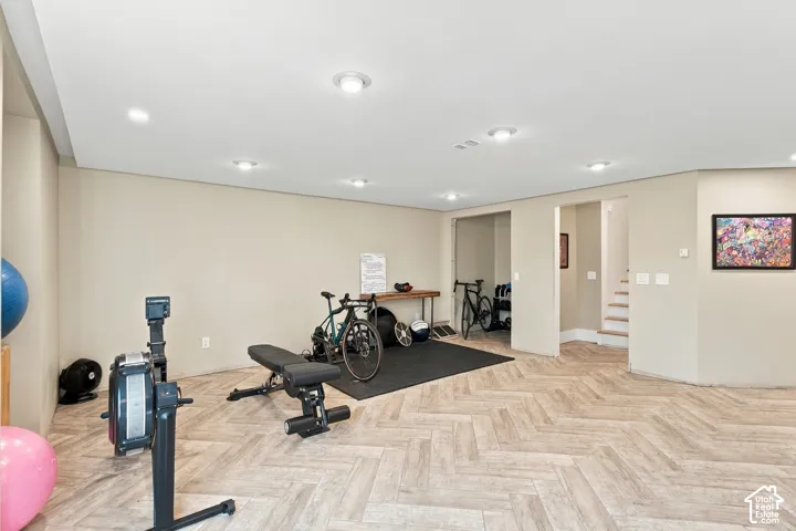 Open floor plan featuring wood-finish flooring in a herringbone pattern and recessed ceiling lighting