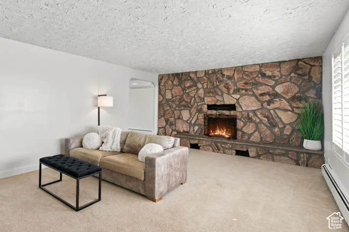 Floor-to-ceiling flagstone fireplace with integrated stone hearth, textured ceiling, and louvered shutters