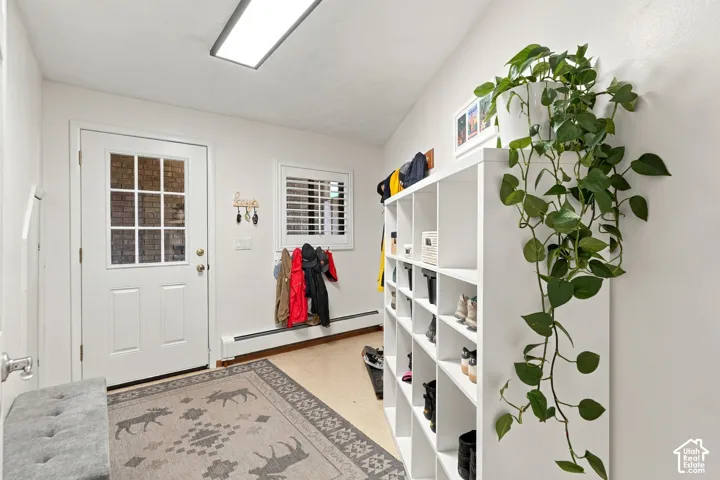 Entryway featuring a white door with a nine-pane glass insert, plantation shutters, and a flush-mount rectangular light fixture
