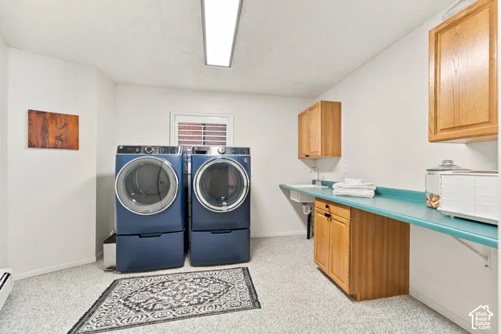 Laundry room featuring wood-finish cabinetry, a solid-surface countertop, an integrated utility sink, and recessed ceiling lighting