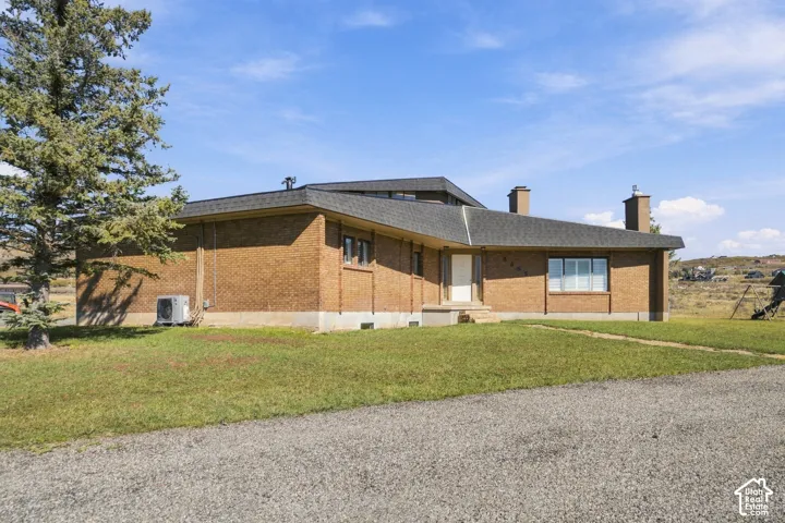 Brick exterior featuring a multi-level roofline, dual masonry chimneys, and concrete foundation