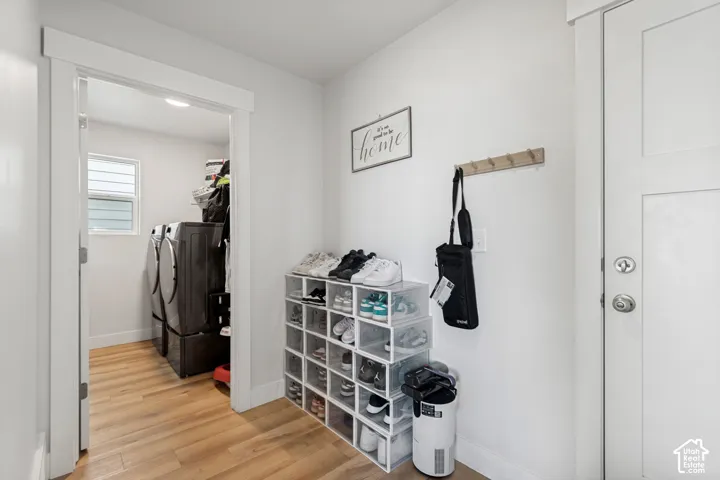Laundry area with wood-finish flooring and a window