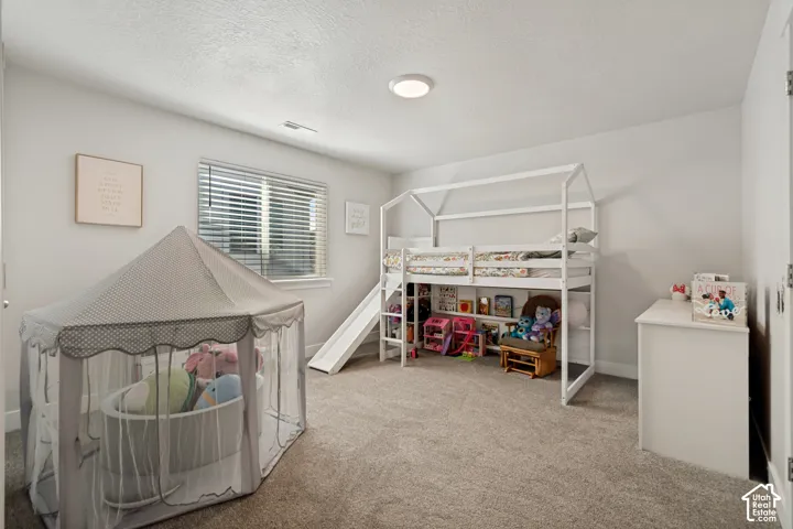 Recessed lighting, window with blinds, carpeted flooring, and light-toned walls