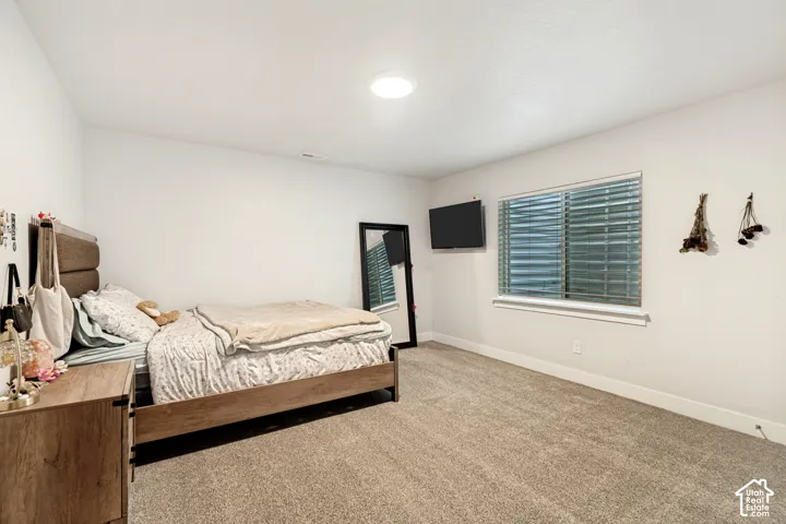 Carpeted flooring, recessed ceiling light, white walls, and a window with blinds