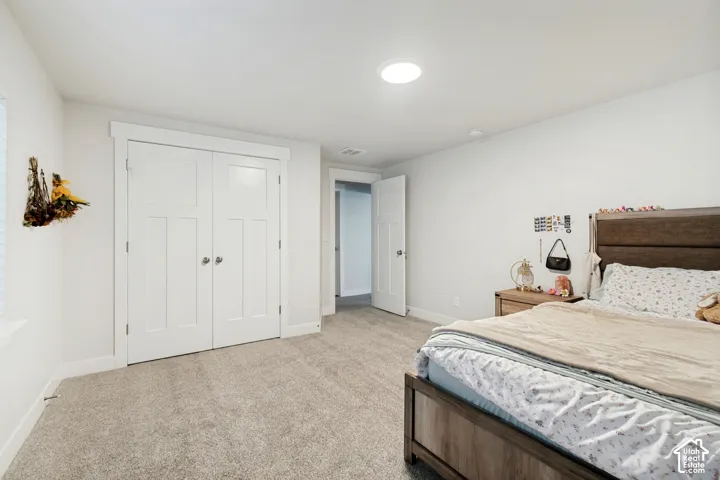 Light gray carpet flooring, white walls, white paneled doors, and a recessed ceiling light